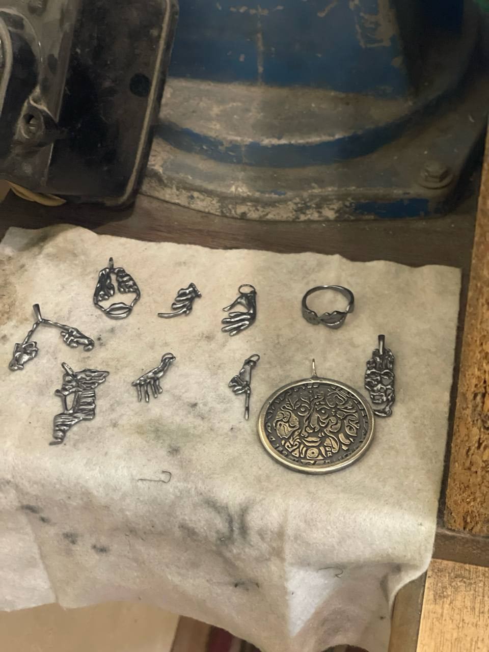 Piezas sobre un paño junto al motor de pulir del taller.
